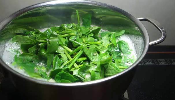 Nồi canh mồng tơi chay đang sôi trên bếp, tỏa hương thơm ngát
