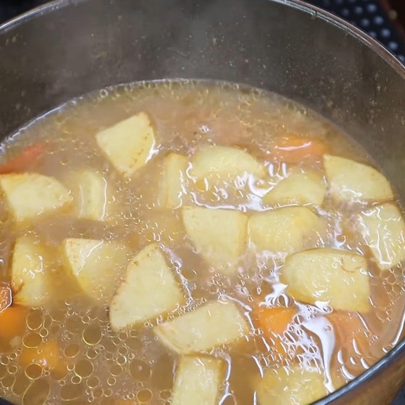 Nồi canh thịt bò rau củ đang được hầm trên bếp lửa