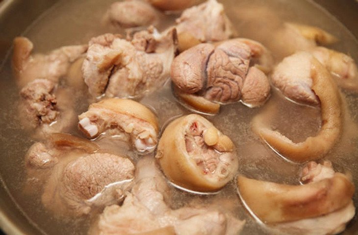 Nồi cháo chân giò truyền thống đang sôi trên bếp, thịt giò heo mềm nhừ