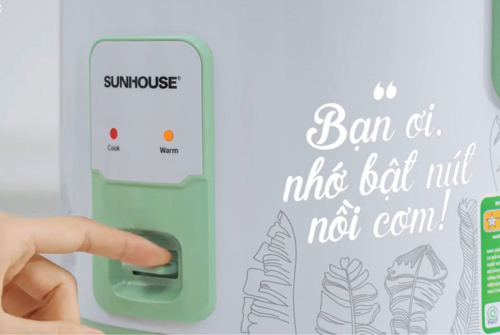 Nồi cơm điện cơ đang ở chế độ "Nấu", chuẩn bị cho mẻ xôi đậu đen nước cốt dừa thơm ngon