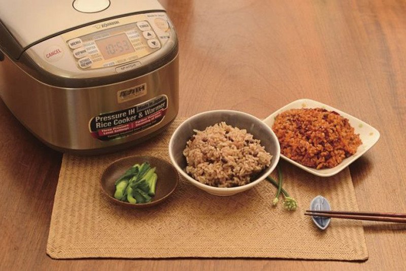 Nồi cơm điện đang nấu gạo lứt đỏ cho bữa ăn dinh dưỡng