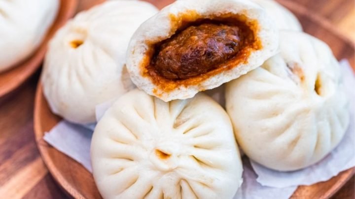 Nồi hấp bánh bao nghi ngút khói, với những chiếc bánh bao trắng mềm trên xửng hấp, tạo cảm giác hấp dẫn và thơm ngon