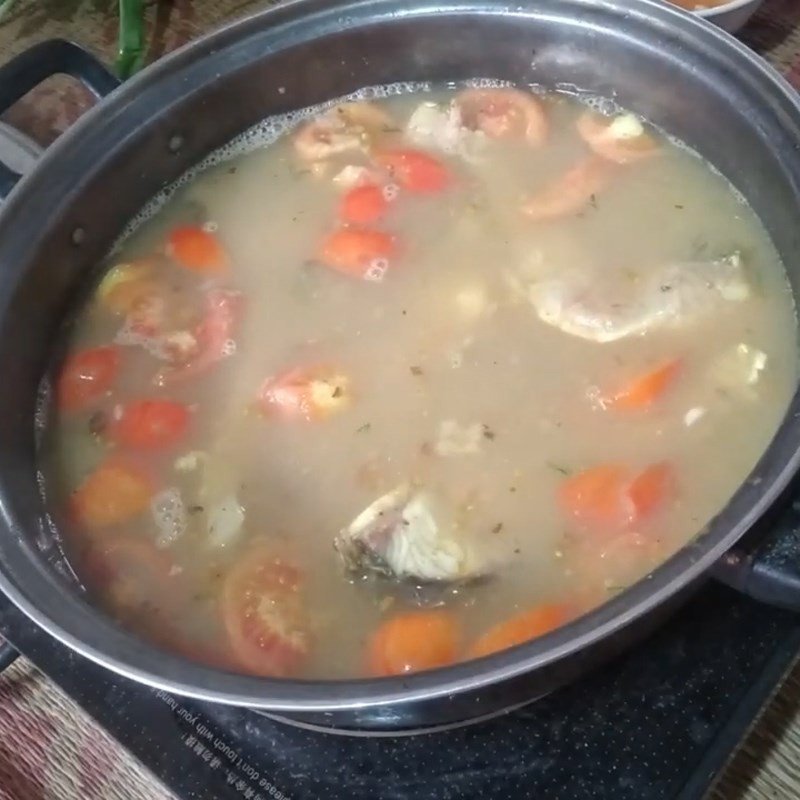 Nồi lẩu cá trắm chua cay thành phẩm với màu sắc hấp dẫn, sẵn sàng cho bữa ăn gia đình.