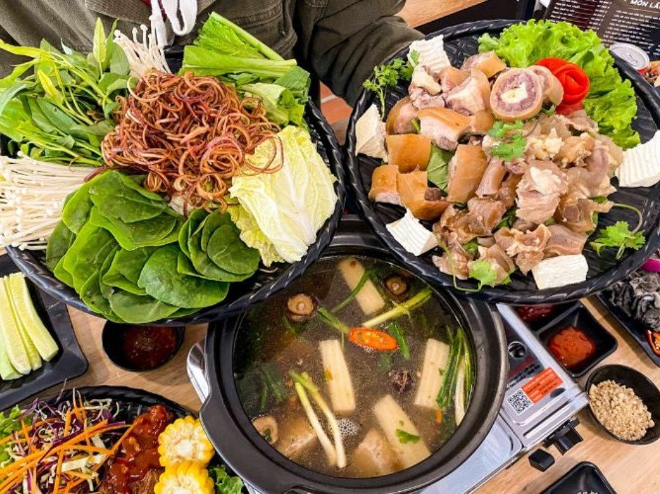 Nồi lẩu chó chuối xanh đang sôi sục trên bếp, tỏa hương thơm