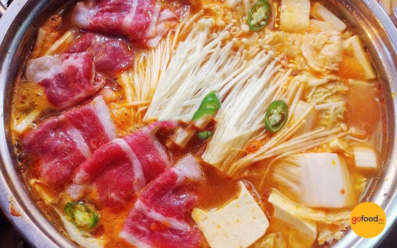 Nồi lẩu kim chi thịt bò nóng hổi với đầy đủ rau củ và topping hấp dẫn
