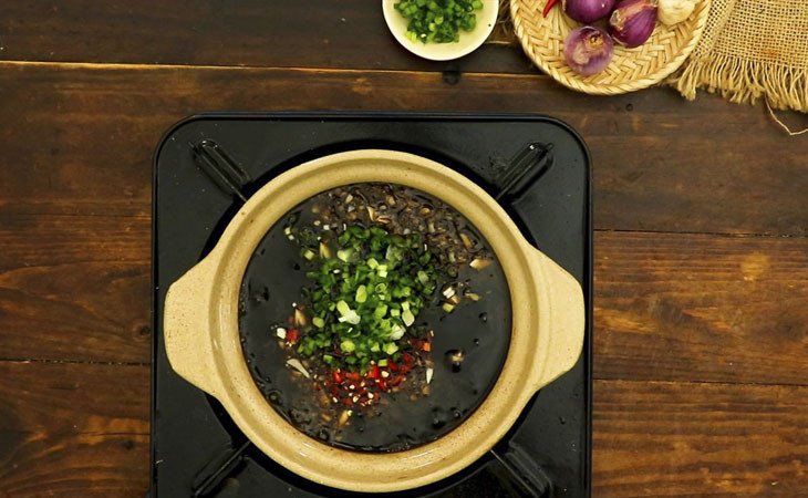 Nồi nước chấm bột chiên đang được đun sôi trên bếp lửa