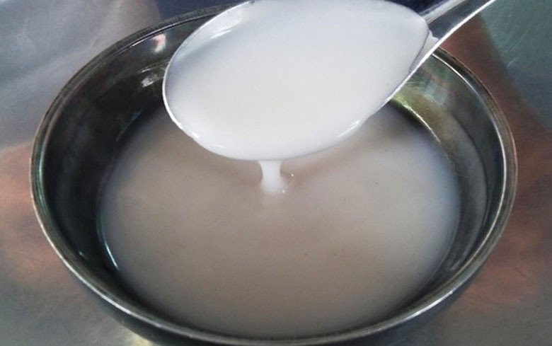 Nồi nước cốt dừa sánh mịn đang được đun trên bếp để hoàn thiện món chè đậu xanh nha đam
