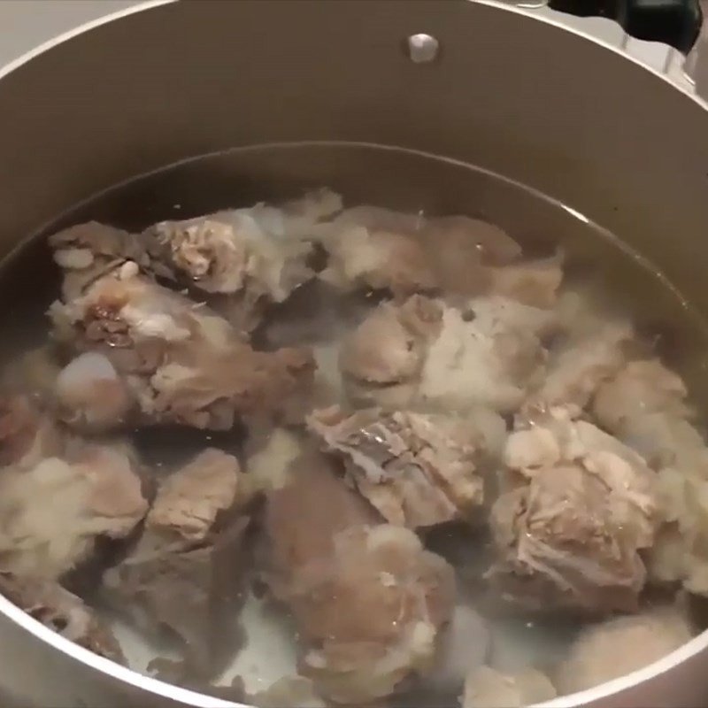 Nồi nước dùng xương heo đang sôi, tạo vị ngọt tự nhiên