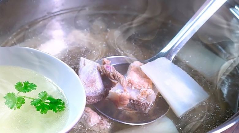 Nồi nước dùng xương heo trong vắt, sóng sánh vàng ươm