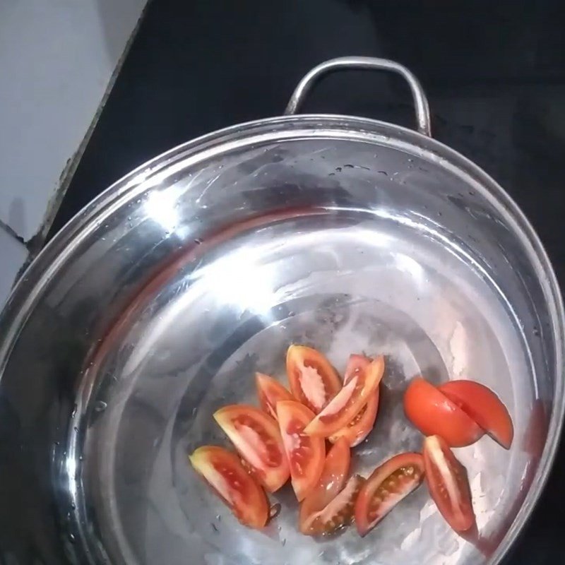 Nồi nước lẩu cá trắm chua cay đang sôi sùng sục, hương thơm lan tỏa.