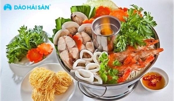 Nồi nước lẩu chua ngọt đang sôi nhẹ với rau củ, chuẩn bị cho việc nhúng các loại hải sản tươi ngon