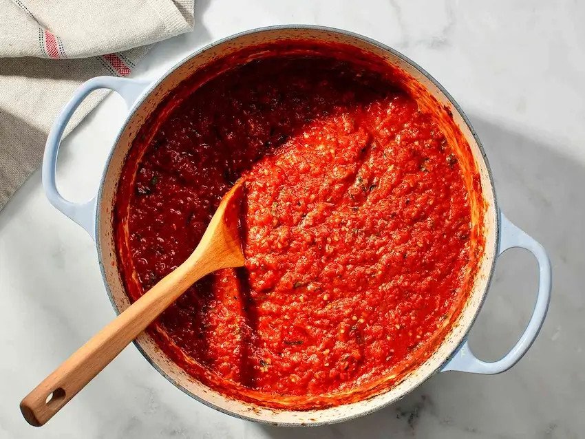 Nồi sốt cà chua tự làm cho pizza thập cẩm với hương thơm của tỏi, hành tây và các loại thảo mộc.