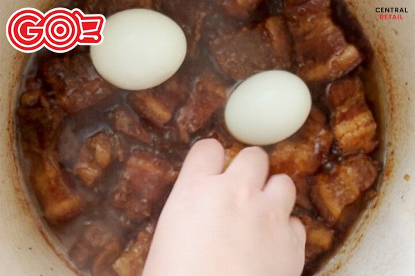 Nồi thịt kho trứng đang sôi nhẹ trên bếp, thịt và trứng ngấm đều gia vị