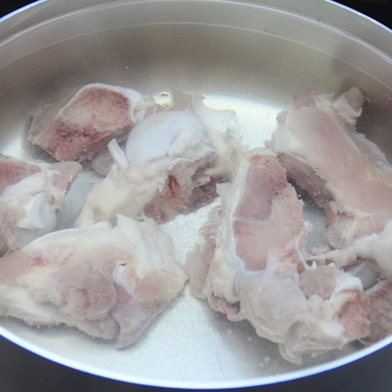 Nồi xương heo đang hầm sôi, lớp bọt cần được vớt ra để nước dùng trong và ngọt hơn
