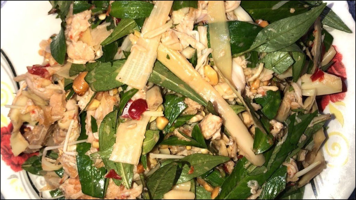 Nộm hoa chuối thịt lợn đã hoàn thành, bày ra đĩa với rau thơm và đậu phộng