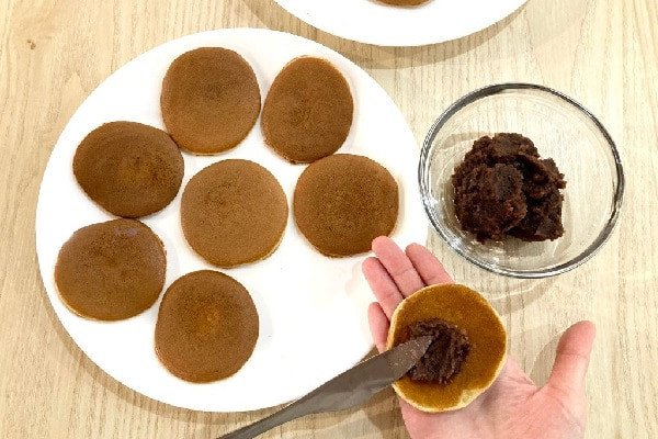 Phết nhân đậu đỏ vào giữa bánh rán doremon