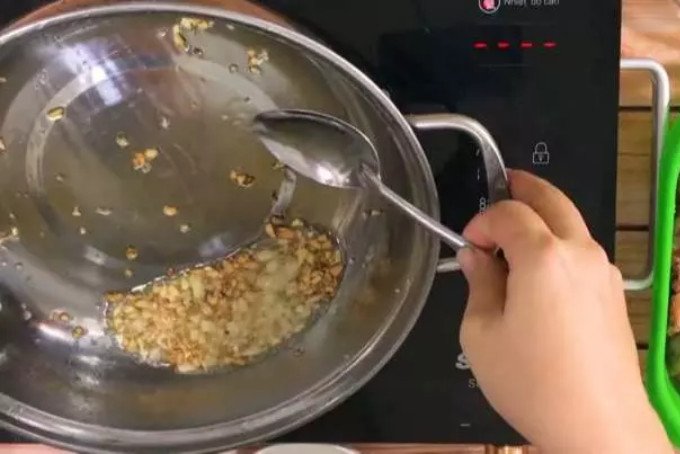 Phi thơm tỏi và sả băm trên chảo để nấu nước lẩu gà lá giang