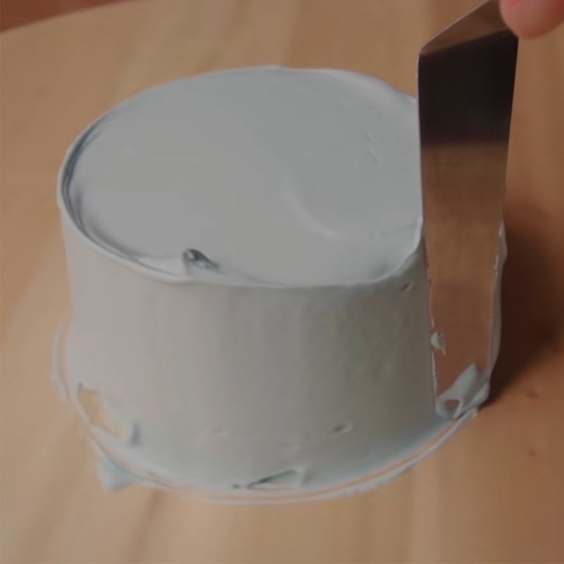 Phủ một lớp kem nền mỏng đều lên bề mặt bánh kem nhỏ