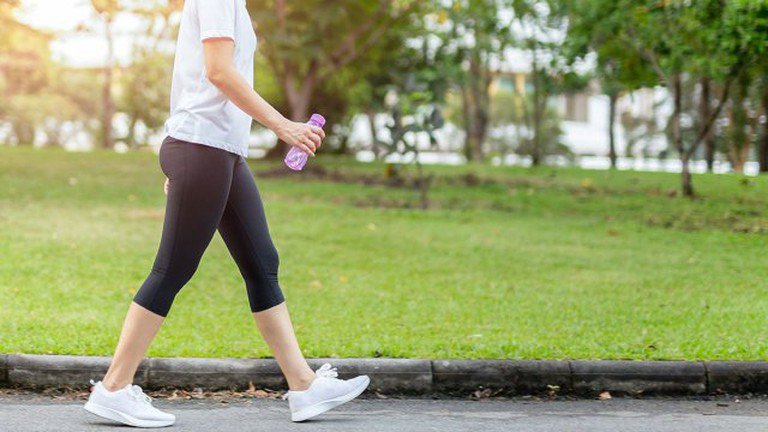 Phụ nữ trẻ đi bộ nhanh để đốt cháy calo và giảm cân