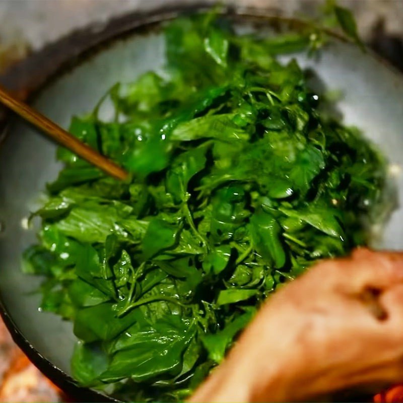 Rau tầm bóp đang được xào nhanh trên chảo nóng
