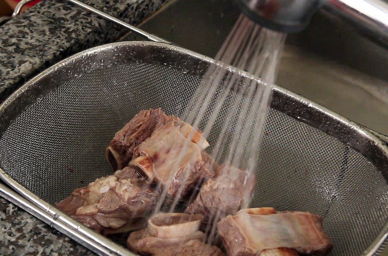 Rửa nhẹ sườn bò trước khi hầm với rau củ