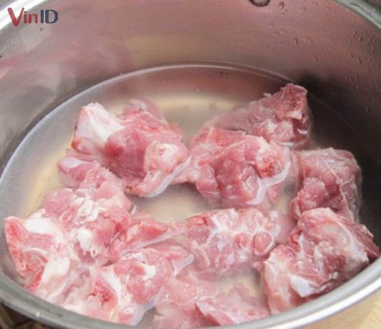 Sơ chế kỹ xương heo để có nước dùng trong, chuẩn bị cho món canh cà tím nấu xương thơm ngon.