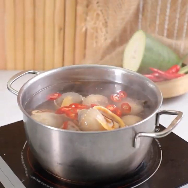Sơ chế và luộc ốc tỏi cùng sả để khử mùi tanh
