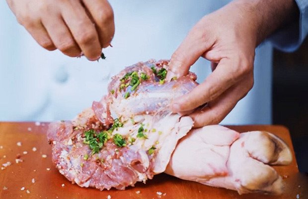 Tẩm ướp gia vị cho miếng thịt chân giò để làm thịt xông khói