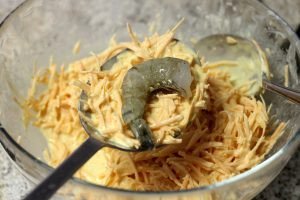 Tạo hình bánh tôm với tôm đặt lên hỗn hợp khoai và bột