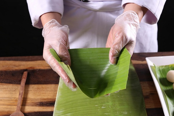 Thao tác gói bánh xu xê truyền thống bằng lá chuối xanh