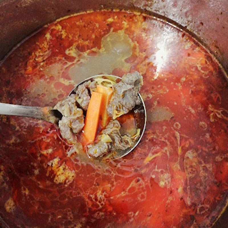 Thêm cà rốt và gia vị vào nồi bò kho đang sôi