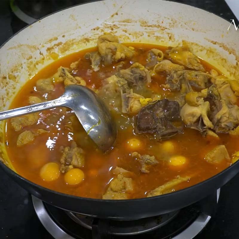 Thêm gia vị vào phần nhân gà đang nấu để làm món mì gà hấp dẫn