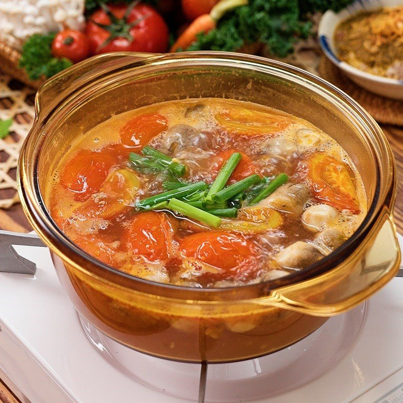 Thêm hành lá thái nhỏ vào nồi lẩu riêu cua nóng hổi