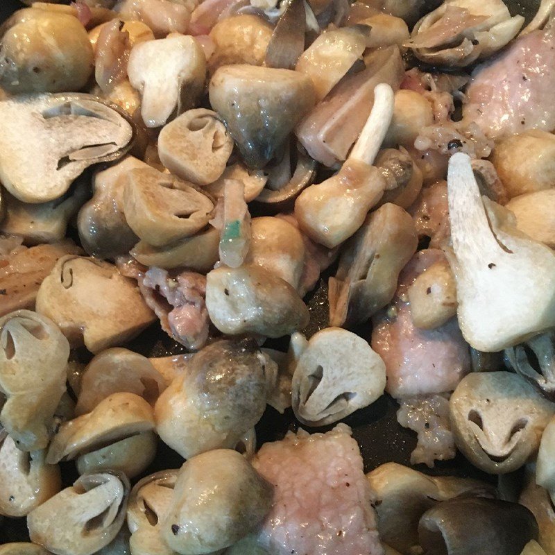 Thêm nấm rơm vào chảo xào chung với thịt lợn