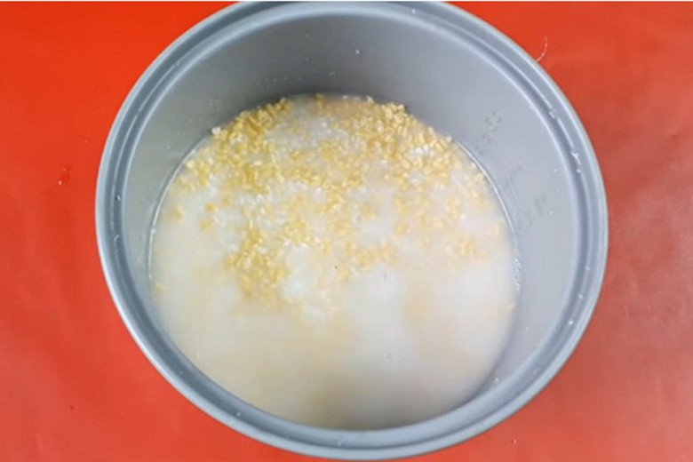Thêm nước cốt dừa và nước sôi vào nồi cơm điện để nấu xôi đậu xanh