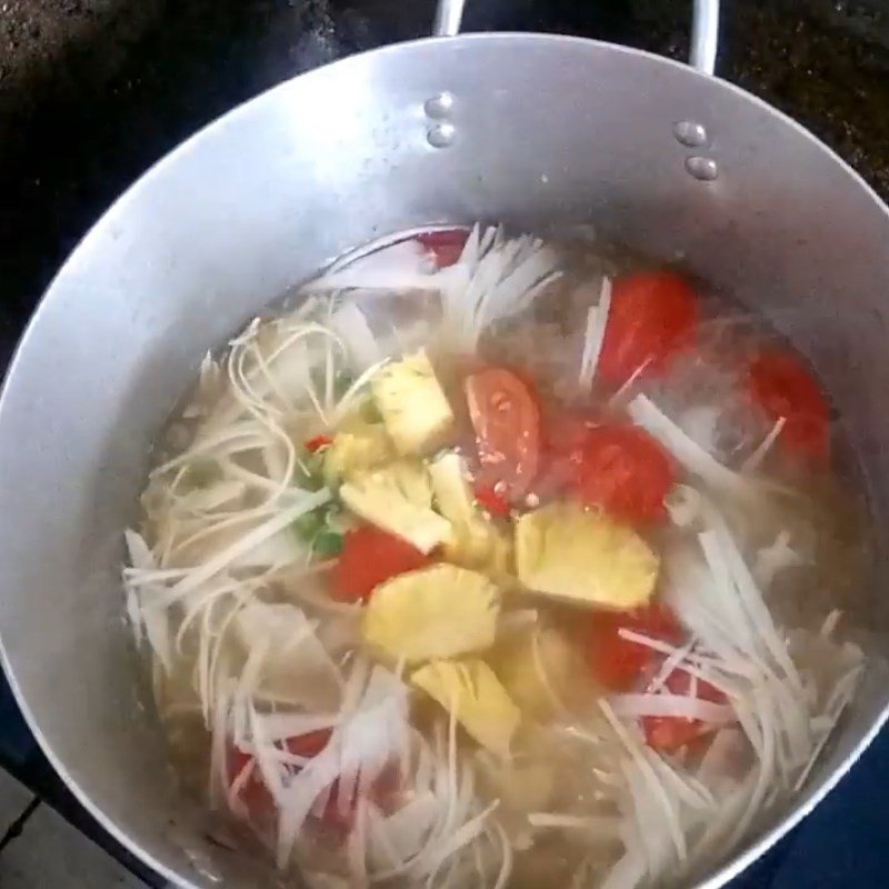 Thêm nước và đun sôi để nấu canh chua cá dìa