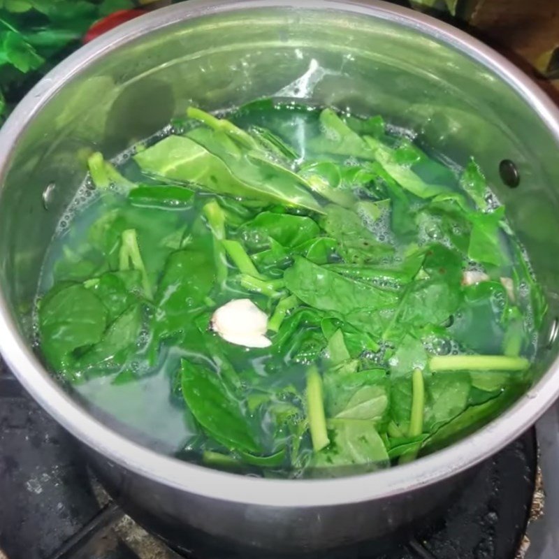Thêm rau mùng tơi vào nồi canh ngao đang sôi