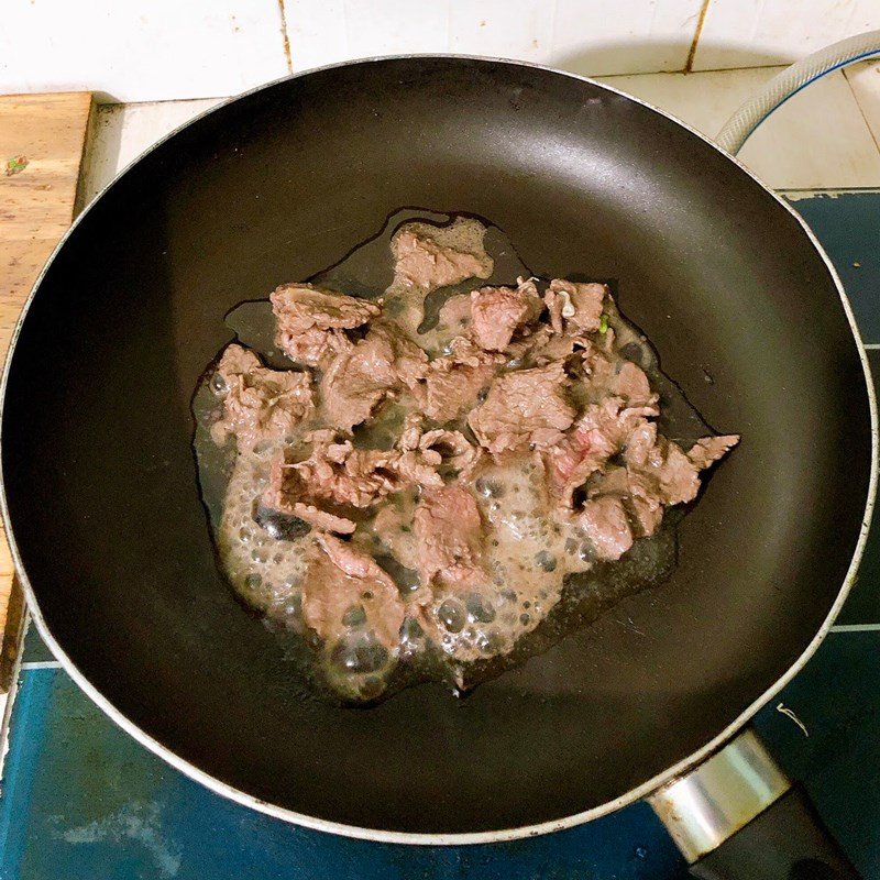 Thêm rau muống vào xào cùng thịt bò trên lửa lớn, đảo đều tay