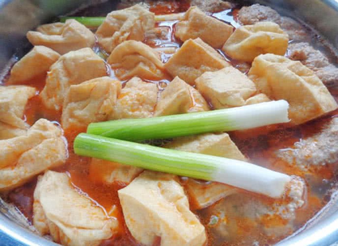 Thêm riêu cua và đậu phụ vào nồi nước dùng canh bún