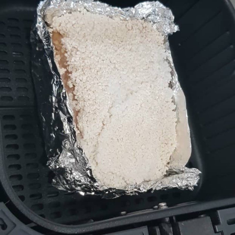 Thịt ba chỉ được bọc giấy bạc và phủ muối hạt chuẩn bị cho lần quay đầu tiên trong nồi chiên không dầu