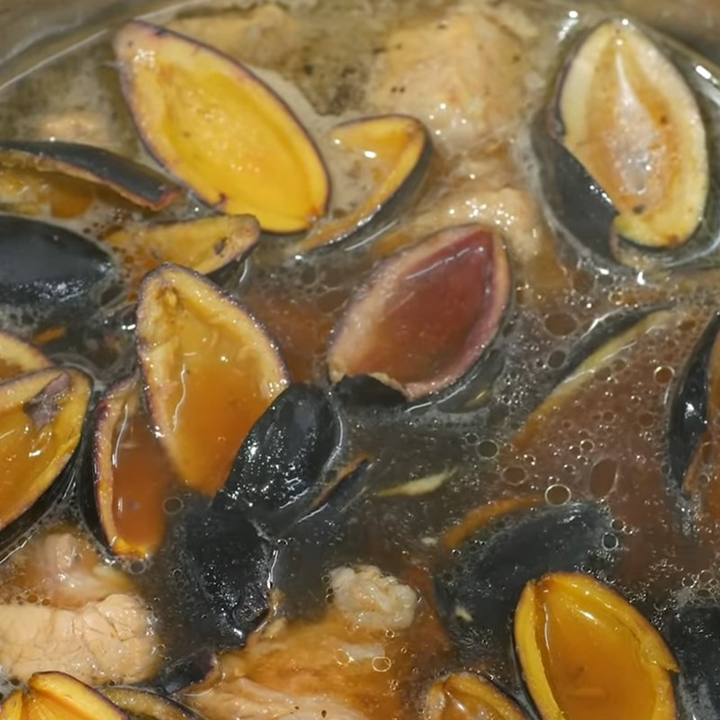 Thịt ba chỉ và trám đen đang được kho chung, hương vị hòa quyện