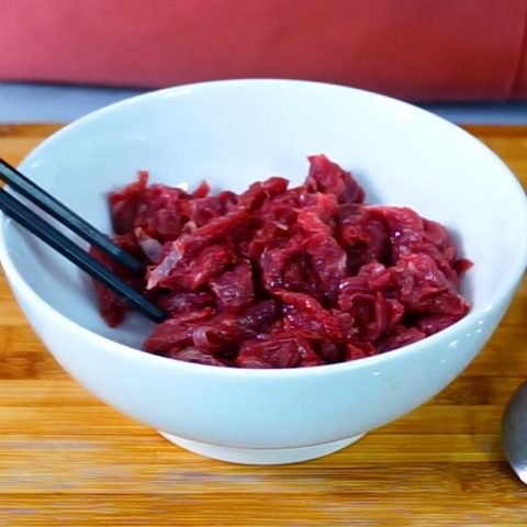 Bí Quyết Cách Xào Ngó Sen Với Thịt Bò Giòn Ngon Chuẩn Vị Thịt bò đã thái lát mỏng đang được ướp gia vị trong tô
