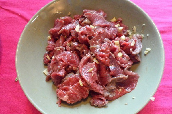Thịt bò thái lát và ướp gia vị chuẩn bị xào