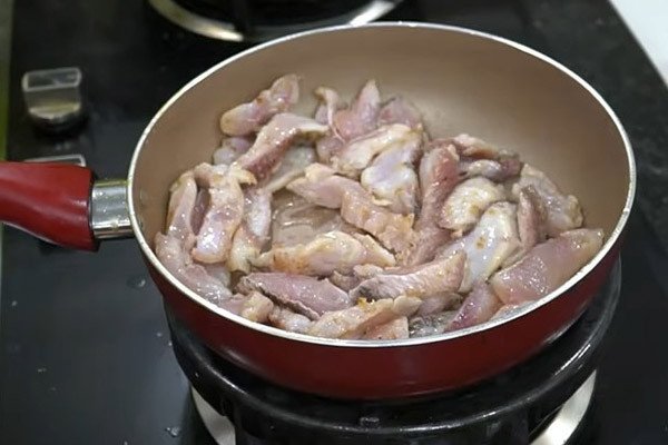Thịt cá lóc đã được phi lê đang xào sơ trên chảo để tăng hương vị