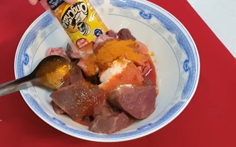 Thịt đà điểu đang được ướp với gia vị cho món xào