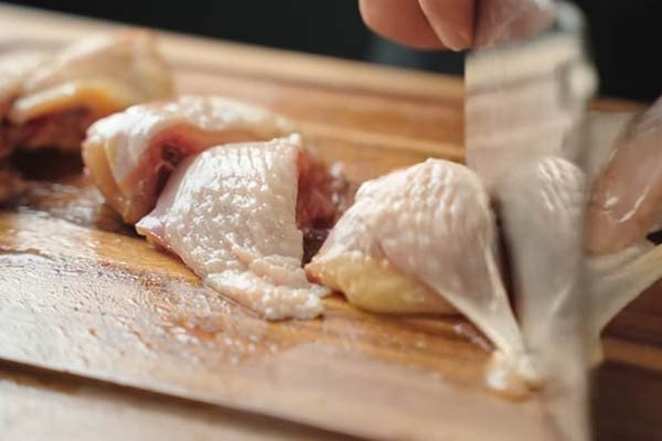 Thịt gà tươi được chặt thành từng miếng đều nhau để chuẩn bị nấu cà ri gà