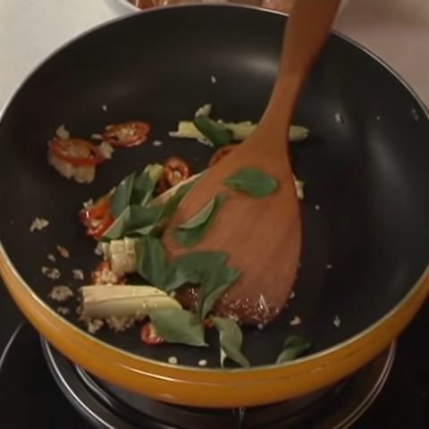 Thịt gà và các gia vị xào lăn đang được phi thơm trên chảo nóng
