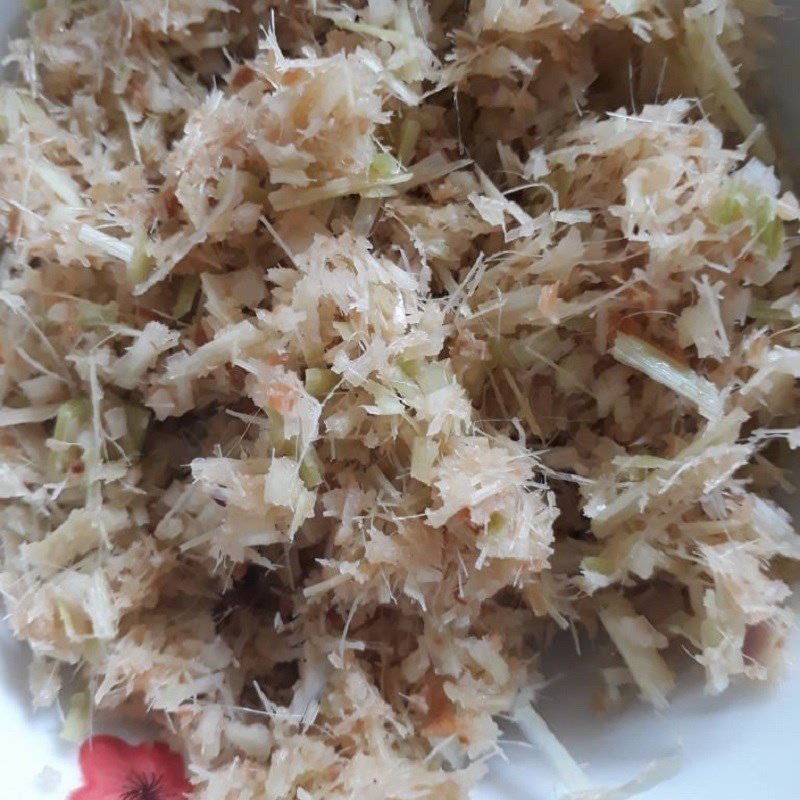 Thịt heo băm đang được trộn đều với mắm ruốc, sả và riềng để ướp