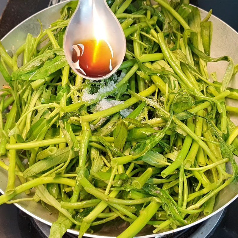 Thịt trâu và rau muống được đảo đều trong chảo nóng