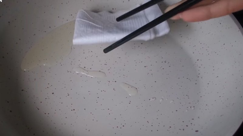 Thoa một lớp dầu mỏng lên chảo chống dính để rán bánh rán Doremon vàng đều.